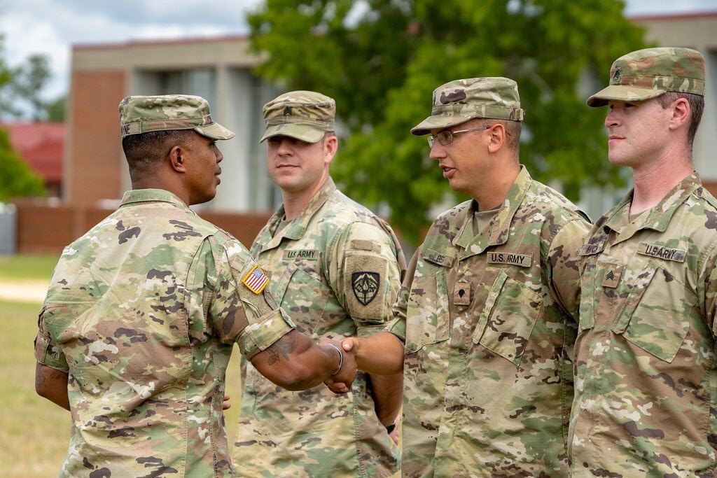 Jason shaking hands with a soldier during a recognition ceremony.